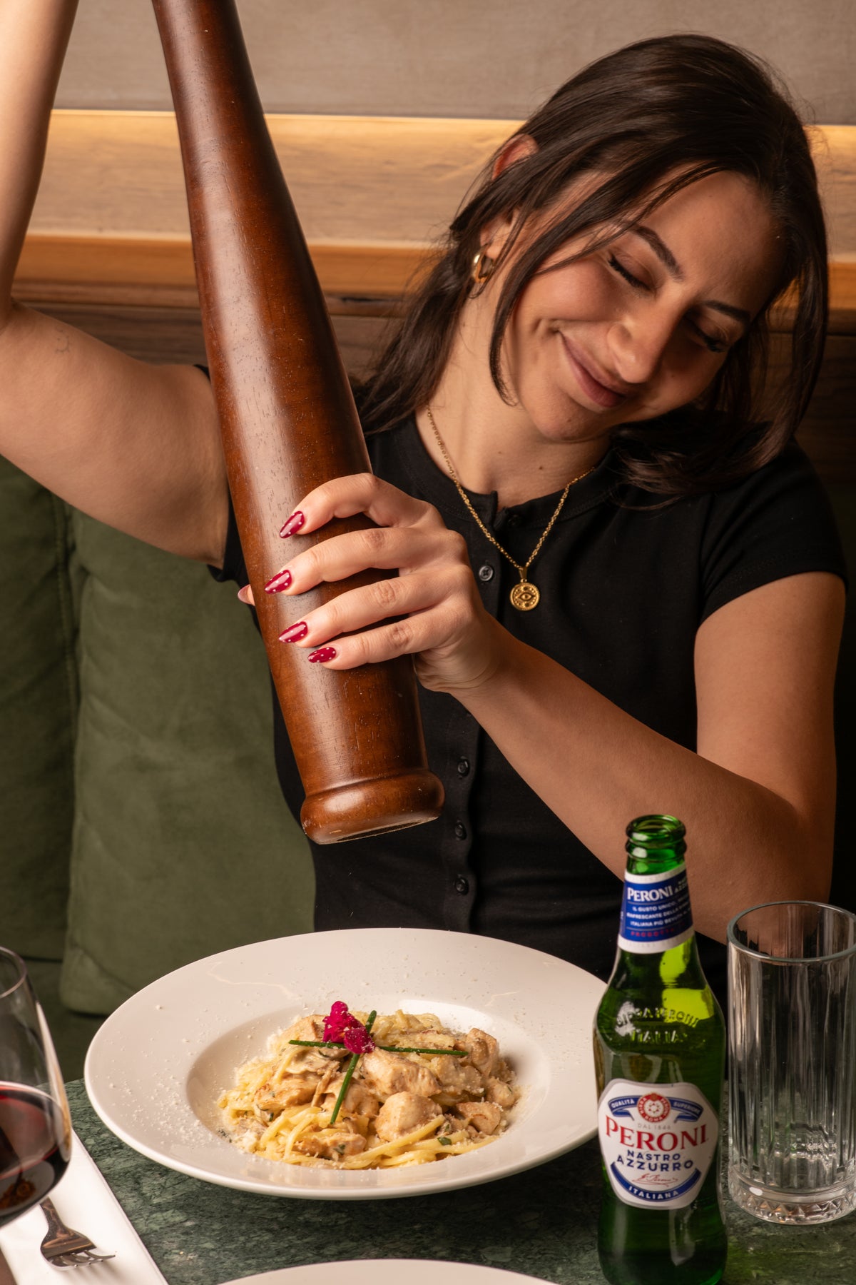 Fresh parmesan and pepper over creamy chicken pasta at Fiena restaurant, King's Cross